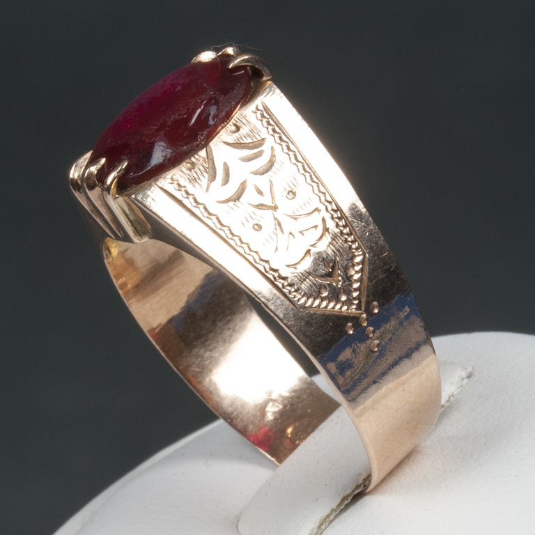A gold ring with a red stone