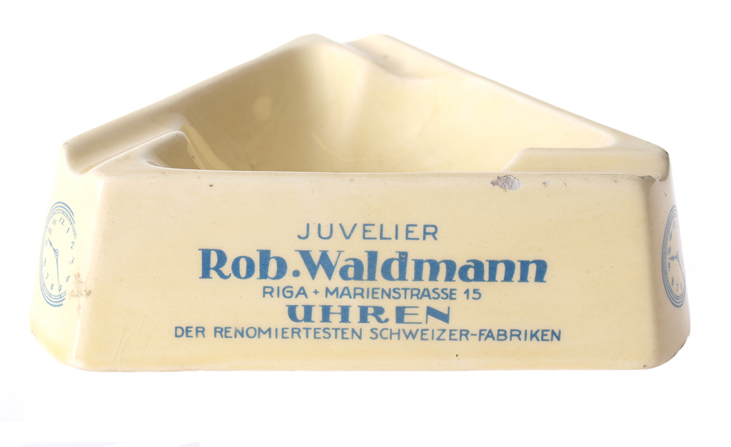 Porcelāna pelnu trauks ar tekstu “Juveliers Rob. Waldmans, Rīgā, Marijas iela 15, pulksteņi no labākām Šveices fabrikām”