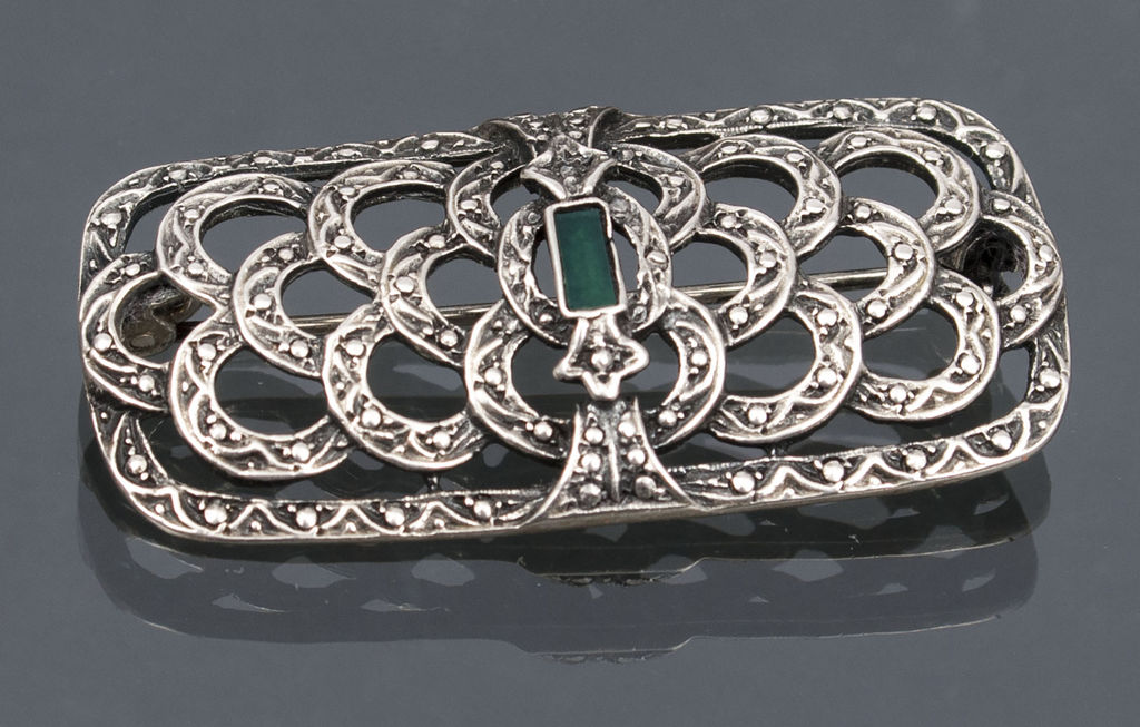Silver brooch with emerald