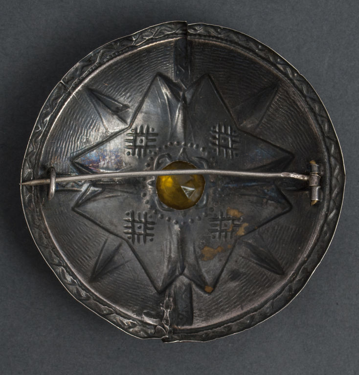 Silver brooch with yellow stone