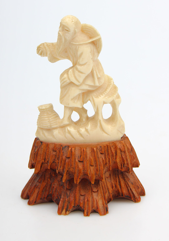 Bone figurine on the wood base 