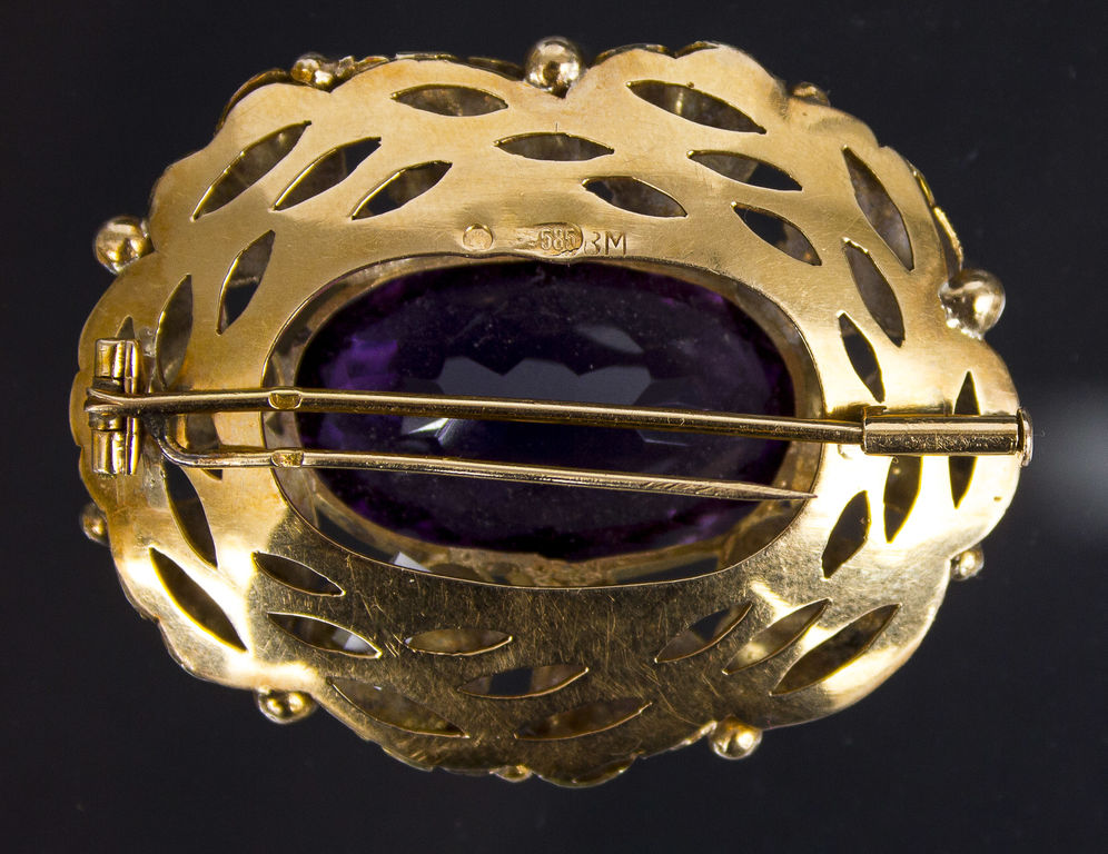 Golden brooch with amethyst