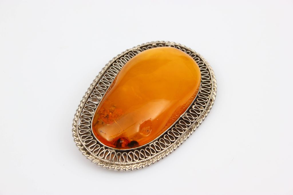 Amber brooch with metal finish