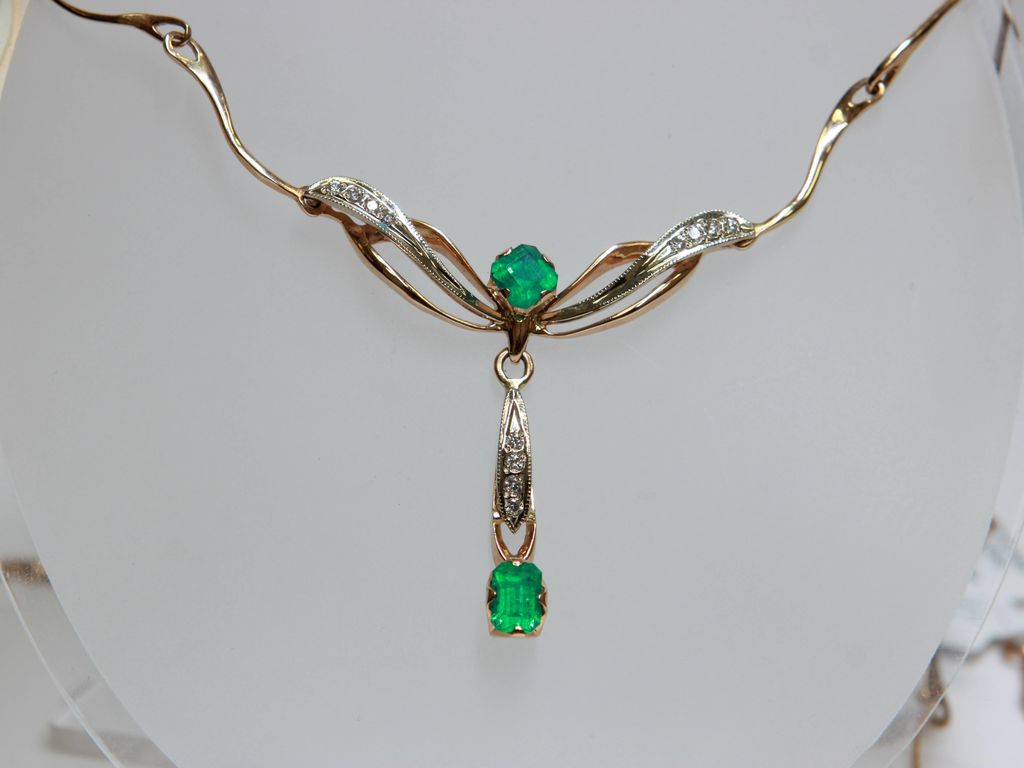 Gold necklace with 12 brilliants, 2 emeralds
