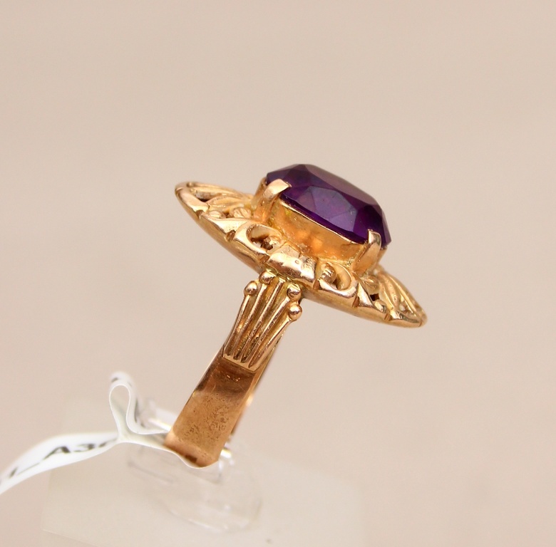 Golden ring with a purple stone