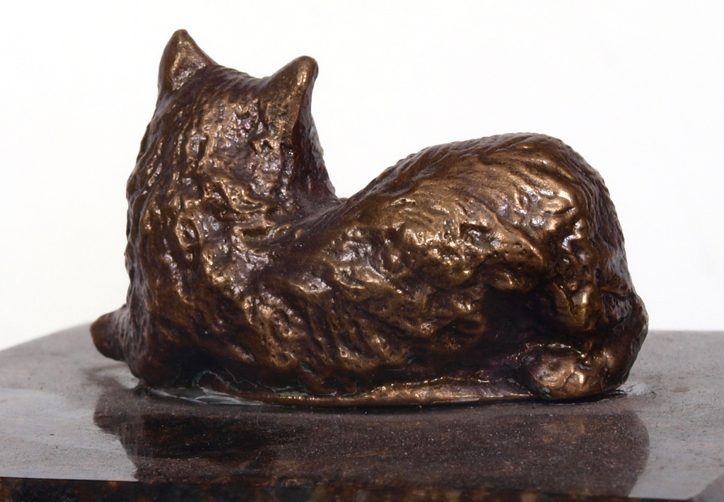 Bronzas kaķis uz marmora pamatnes