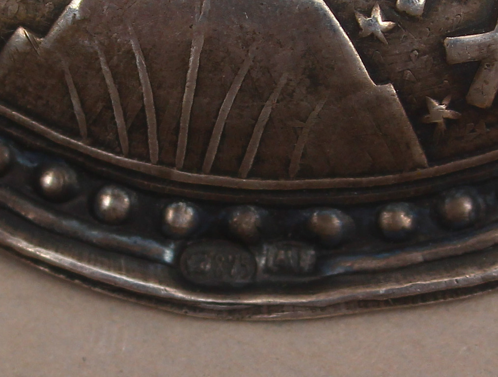 Silver brooch with red stone and Latvian signs