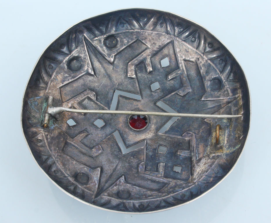 Silver brooch with red stone