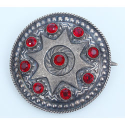 Silver brooch with red stones 