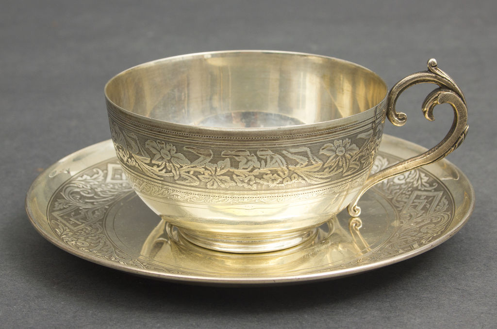 Silver cup with saucer