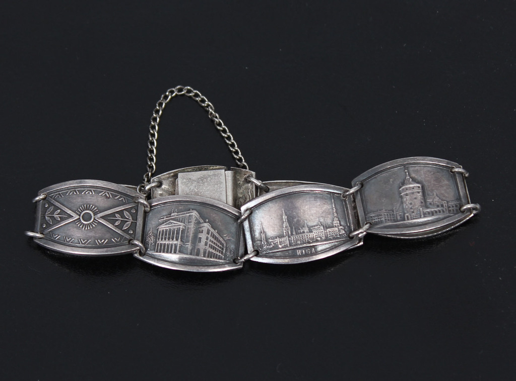 Silver bracelet with various objects in Riga