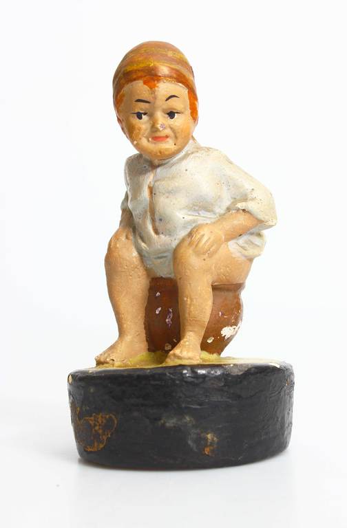 Figurine boy on the toilet