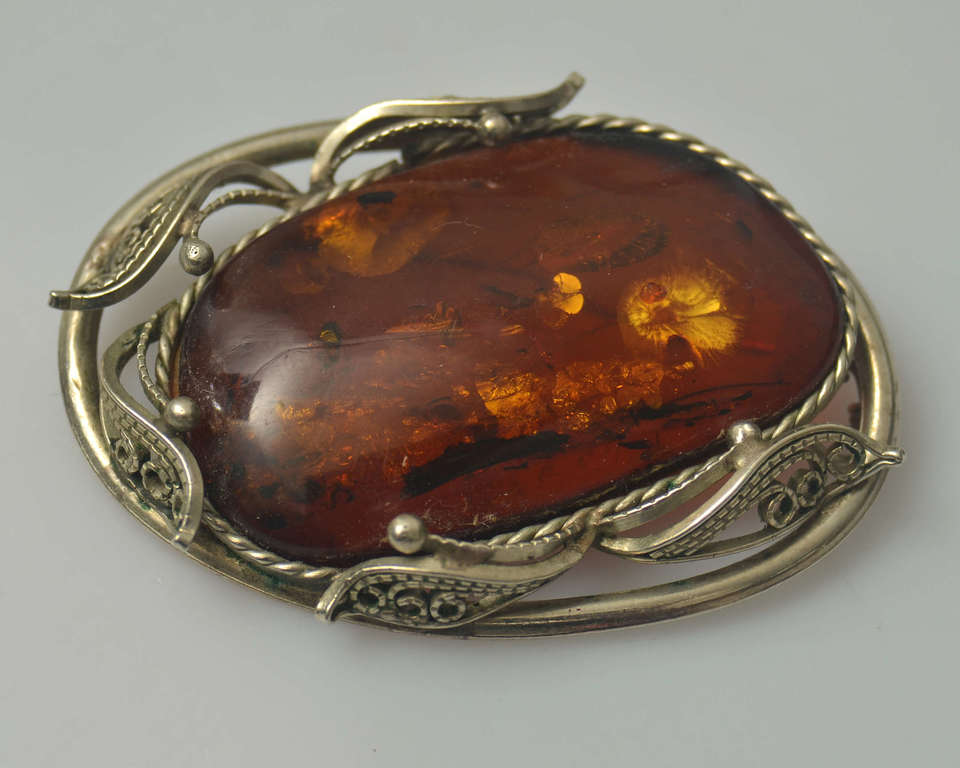 Amber brooch with metal finish
