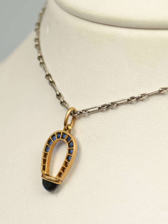 Gold horseshoe with diamonds, sapphire and chain