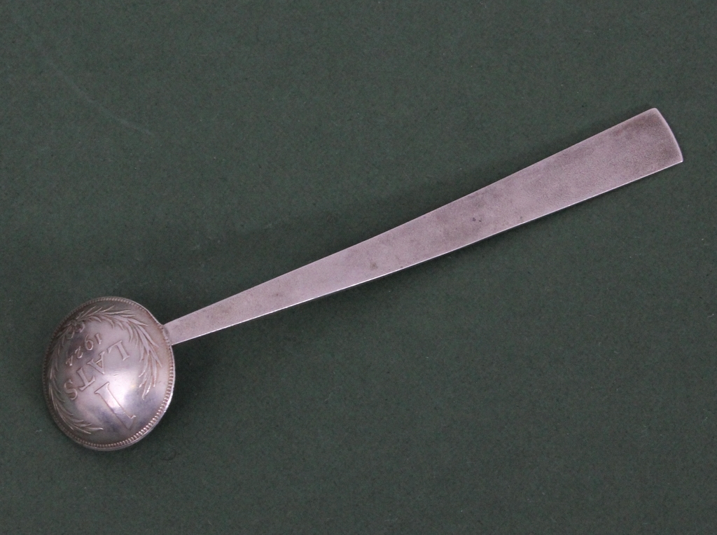 Silver spoon with one Latvian lats coin