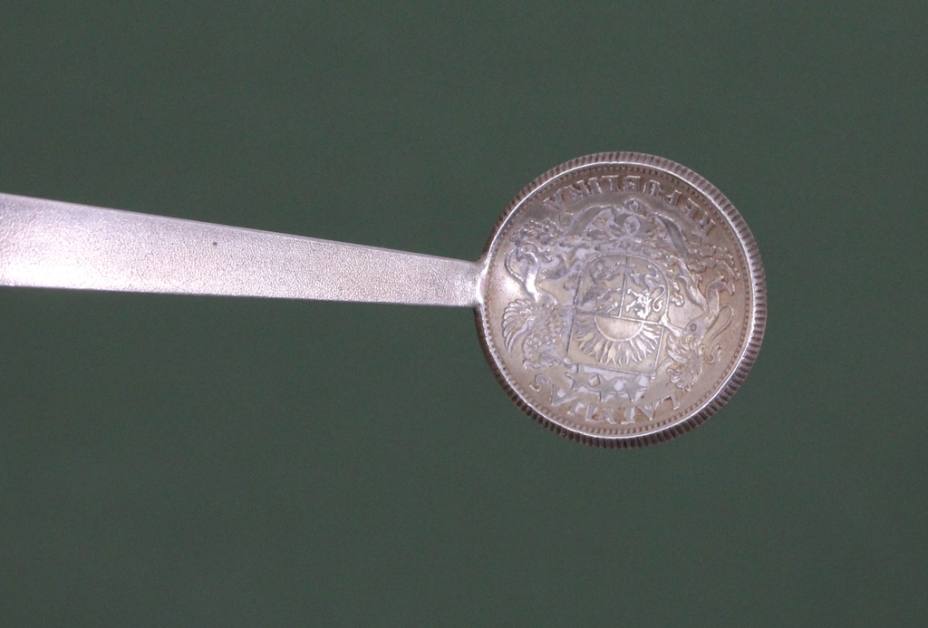 Silver spoon with one Latvian lats coin