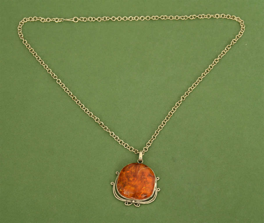 Metal chain and amber pendant in a metal frame