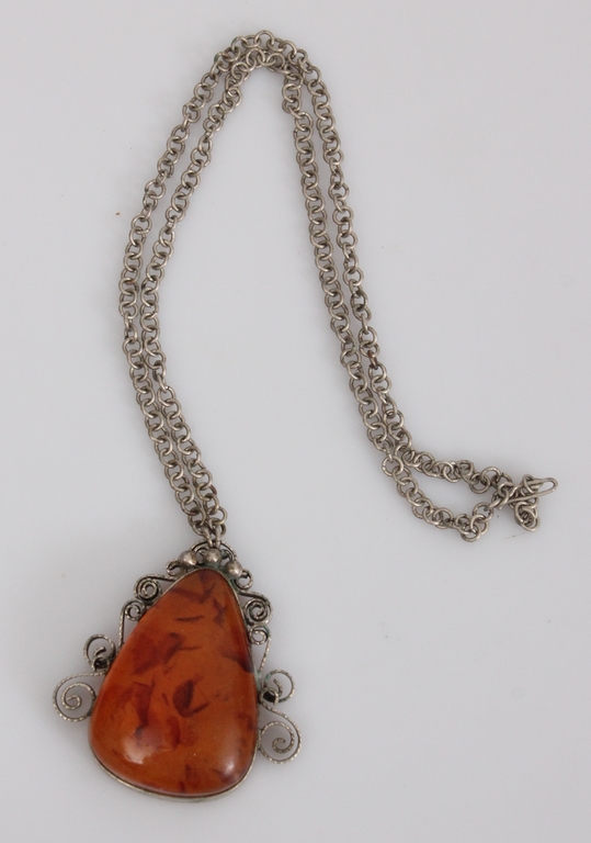Metal chain and amber pendant in a metal frame