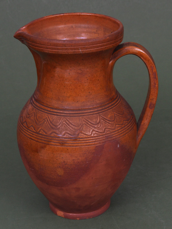 Ceramic pitcher with ornament