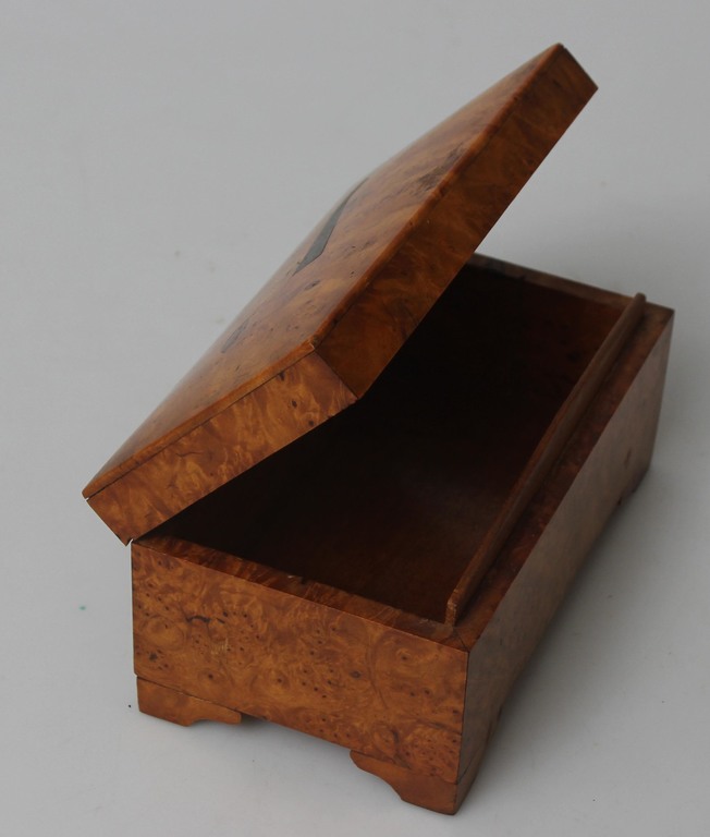 A wooden casket with a pipe