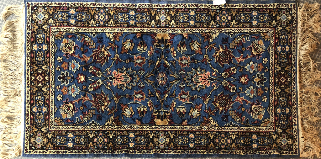 Ar rokām austs zils vilnas paklājs