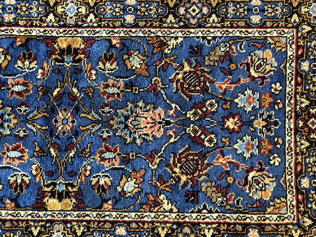 Ar rokām austs zils vilnas paklājs