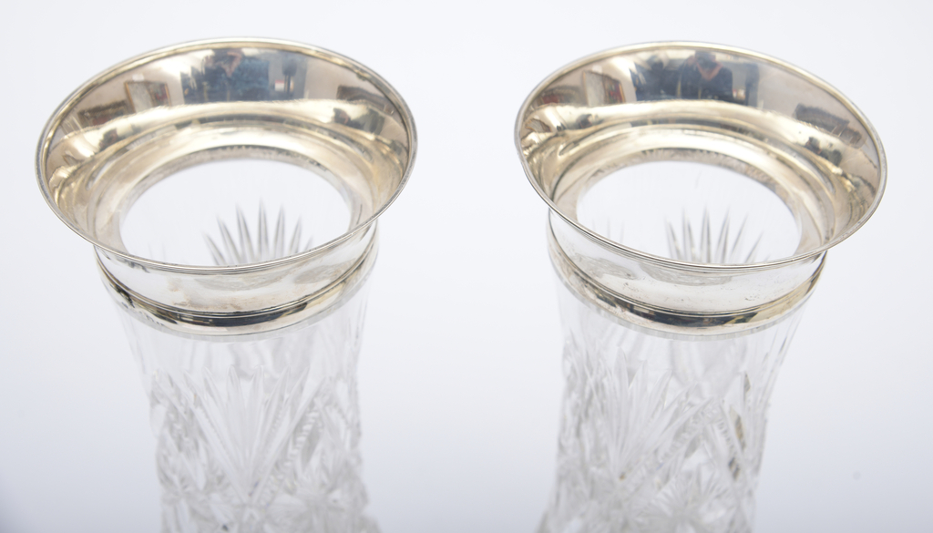 A pair of crystal vases with silver trim