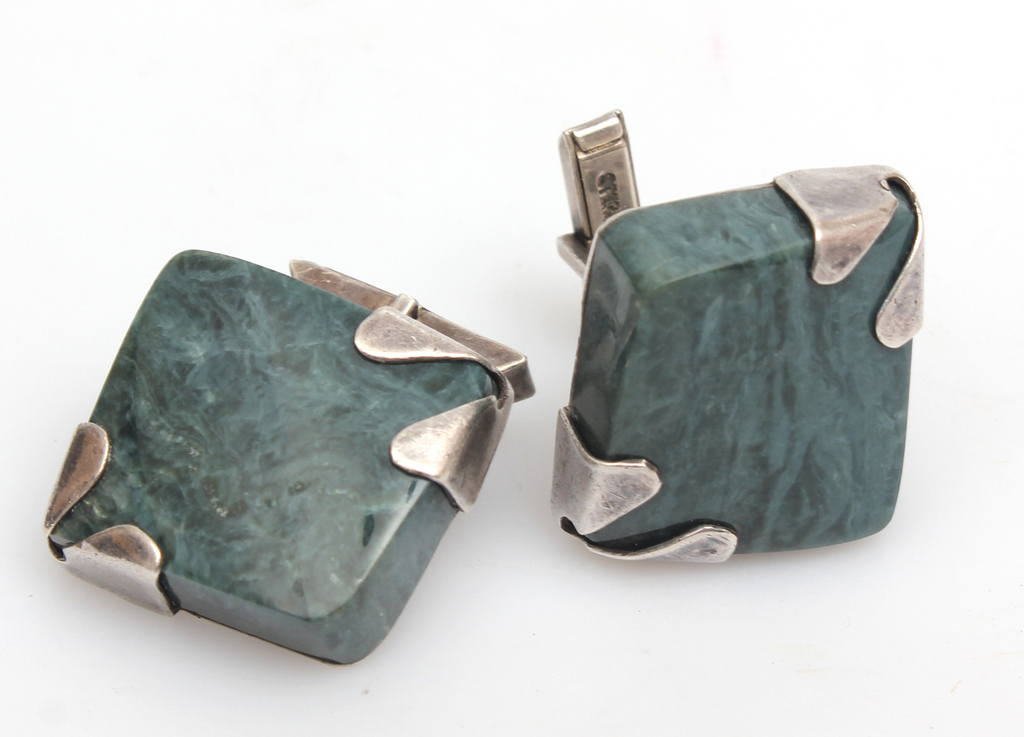 Silver cufflinks with a green colored stone