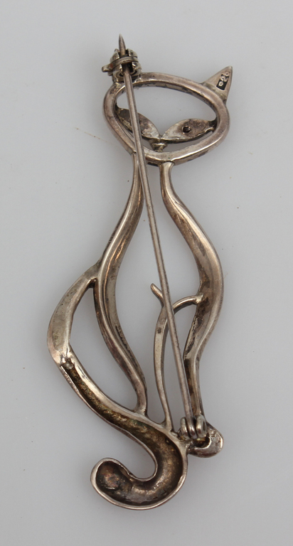 Silver brooch cat with dark colored stones instead of eyes