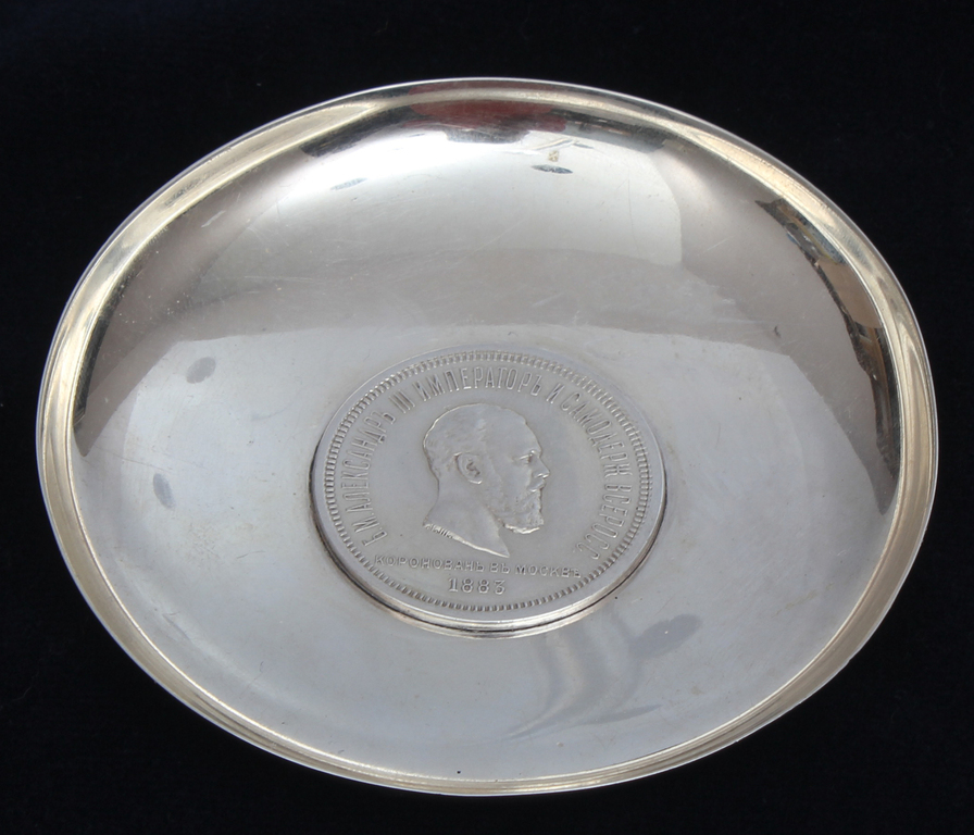 A silver dish with an embedded ruble coin of 1883