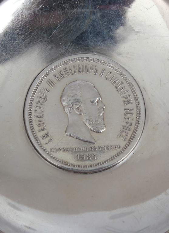 A silver dish with an embedded ruble coin of 1883