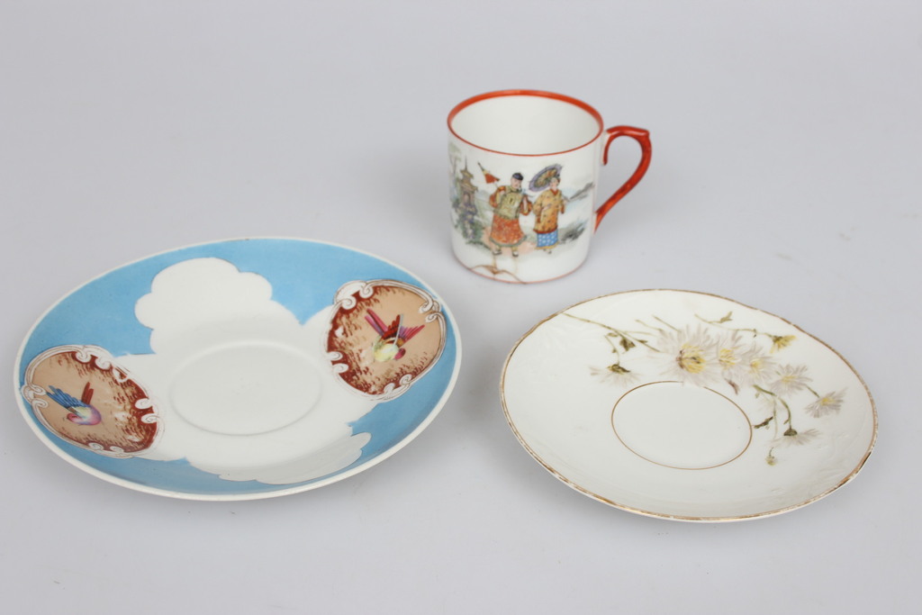 A porcelain cup with a defect and two plates