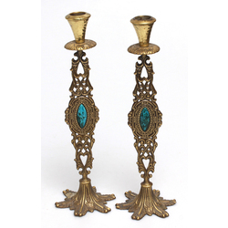 A pair of metal candlesticks with a blue colored stone
