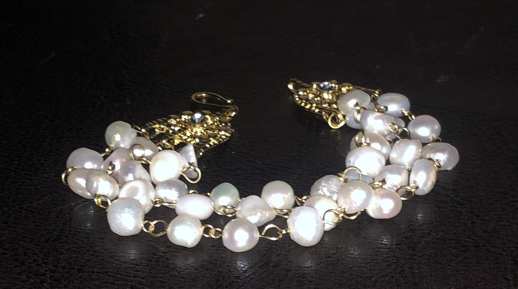 Bracelet with freshwater pearls and gold-plated metal elements.