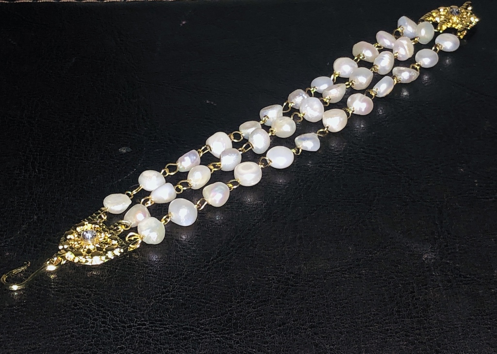 Bracelet with freshwater pearls and gold-plated metal elements.