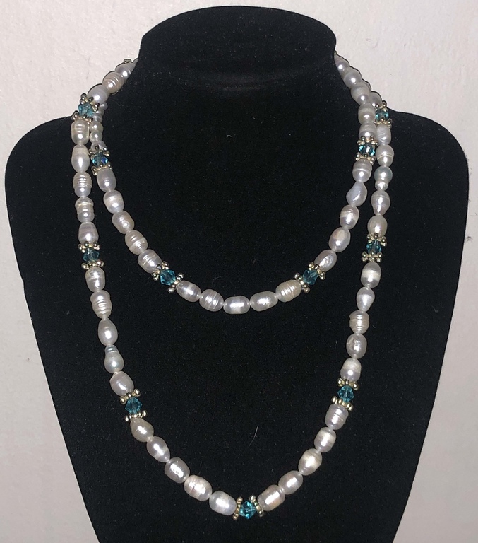 Long white freshwater pearl beads with light blue crystals and other metal elements.