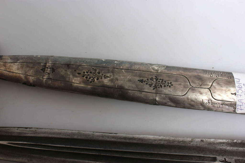 Серебряная кортика с серебряной ручкой и рамкой.